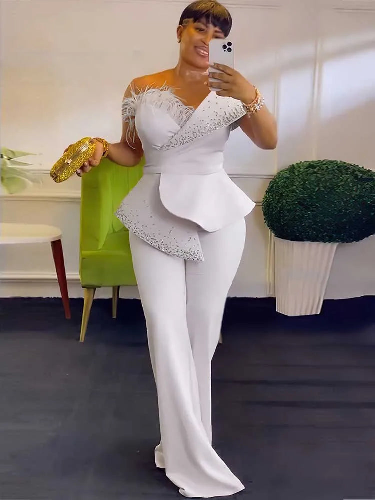 Woman taking a mirror selfie wearing a white off-shoulder dress with lace details.
